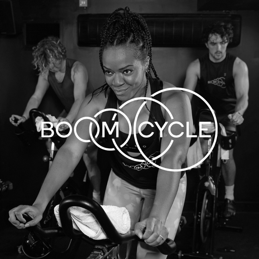 Boom Cycle riders powering through a high-energy indoor cycling class, driven by music, motivation, and an inclusive party-on-a-bike atmosphere.